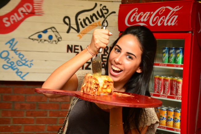 Mohsen poses with her gaint slice of pizza cake [Photo by Engezni] 